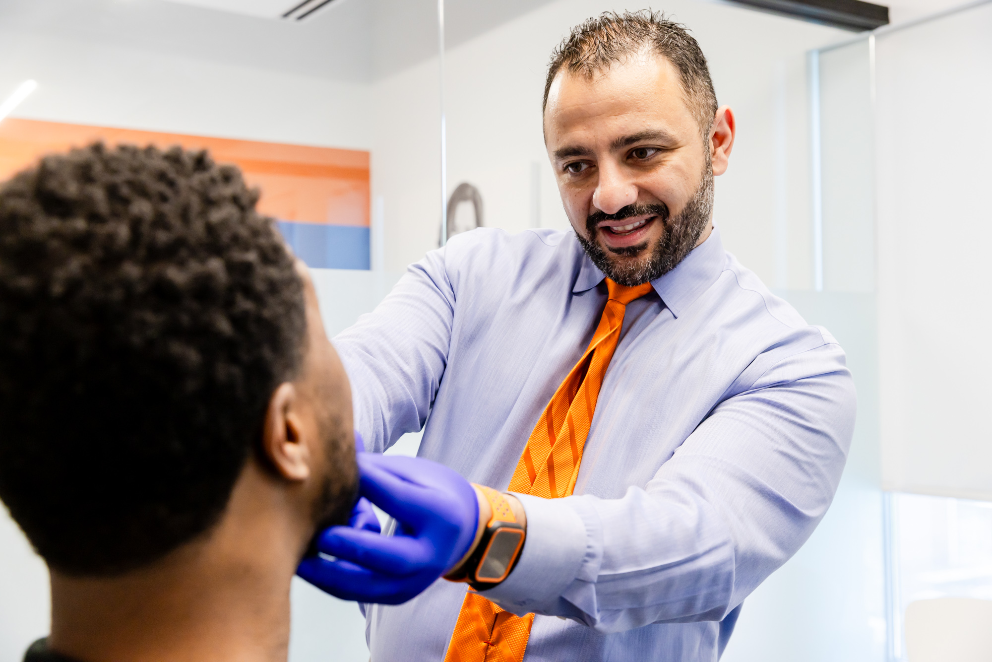 Orthodontist in Fairfax, VA, fitting adult clear aligners on a patient.