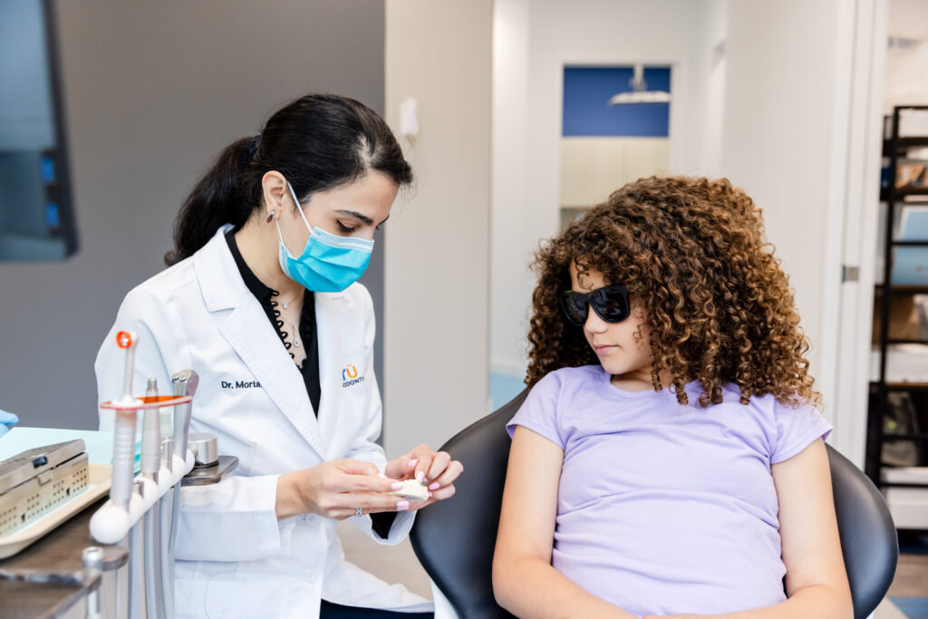 Orthodontist showing a patient her retainers in Herndon, VA