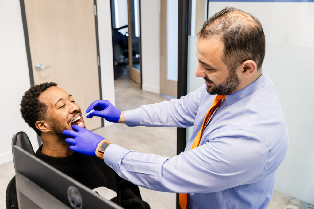 Orthodontist in West Springfield, VA, fitting adult clear aligners on a patient.